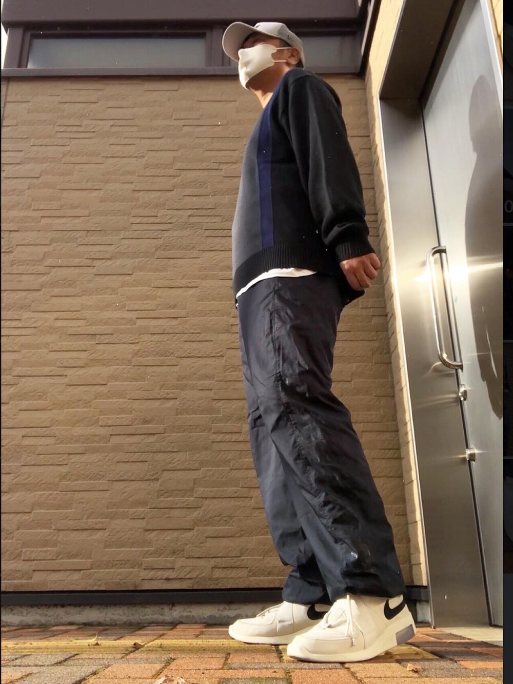 ブラック系のニット/セーター、ブラック系のその他パンツ、ホワイト系のスニーカーを着用したメンズの秋コーディネートの2枚目の写真