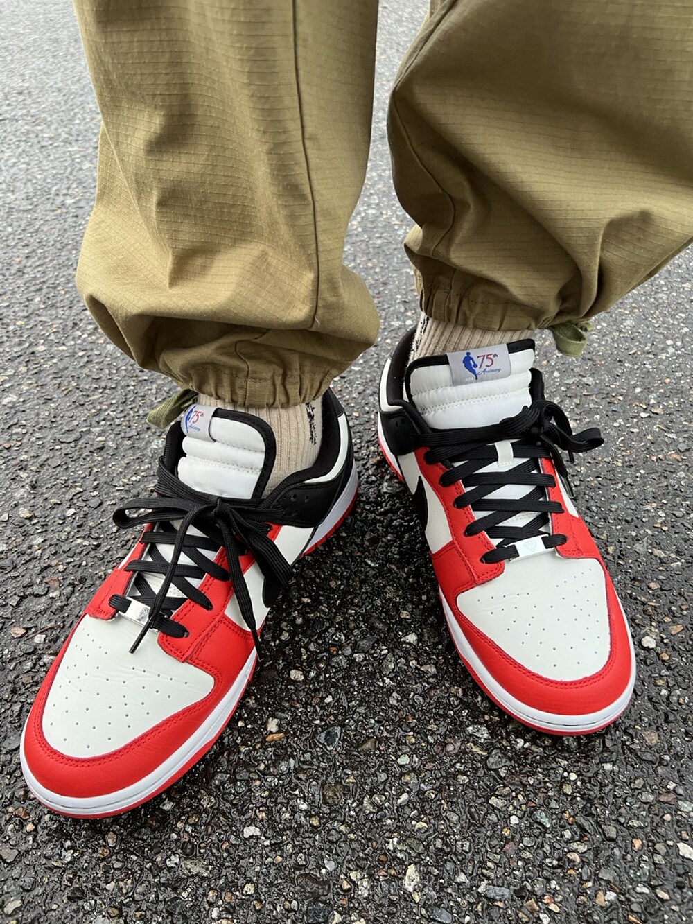 ベージュ系のパンツ、レッド系のスニーカー、レッド系のダウンジャケット/コートを着用したメンズの冬コーディネートの2枚目の写真