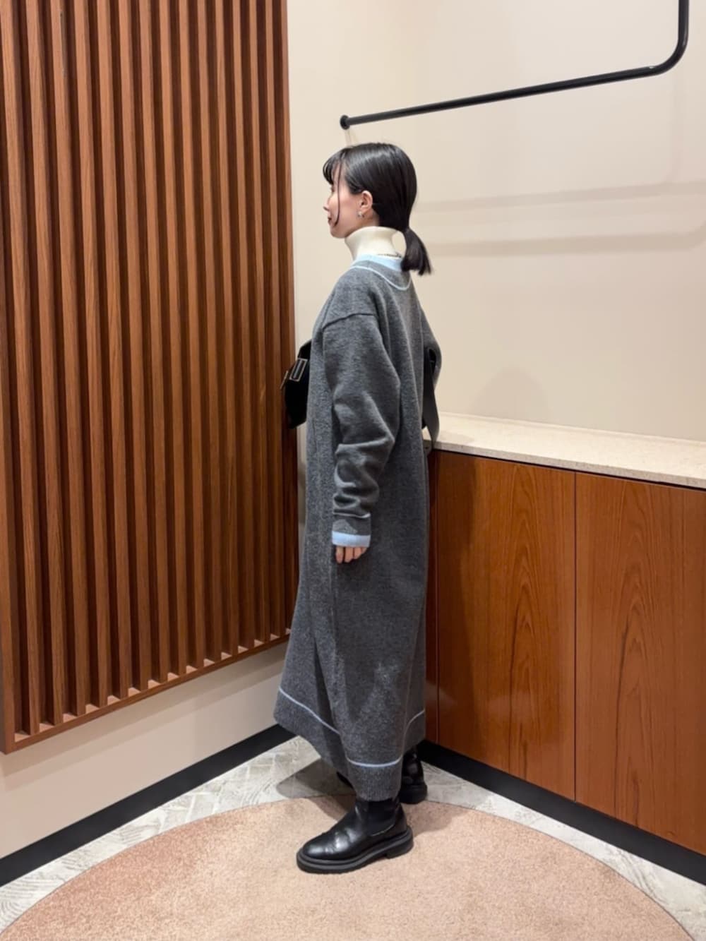 グレー系のワンピース、ホワイト系のニット/セーターを着用したレディースの冬コーディネートの2枚目の写真