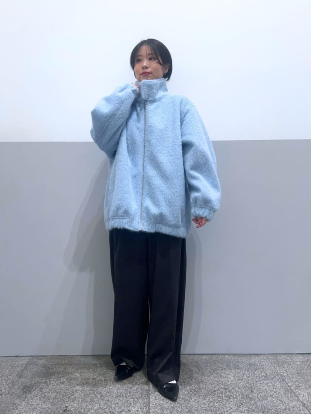 ブルー系のブルゾン、グレー系のその他パンツ、ホワイト系のニット/セーターを着用したレディースの冬コーディネートの2枚目の写真