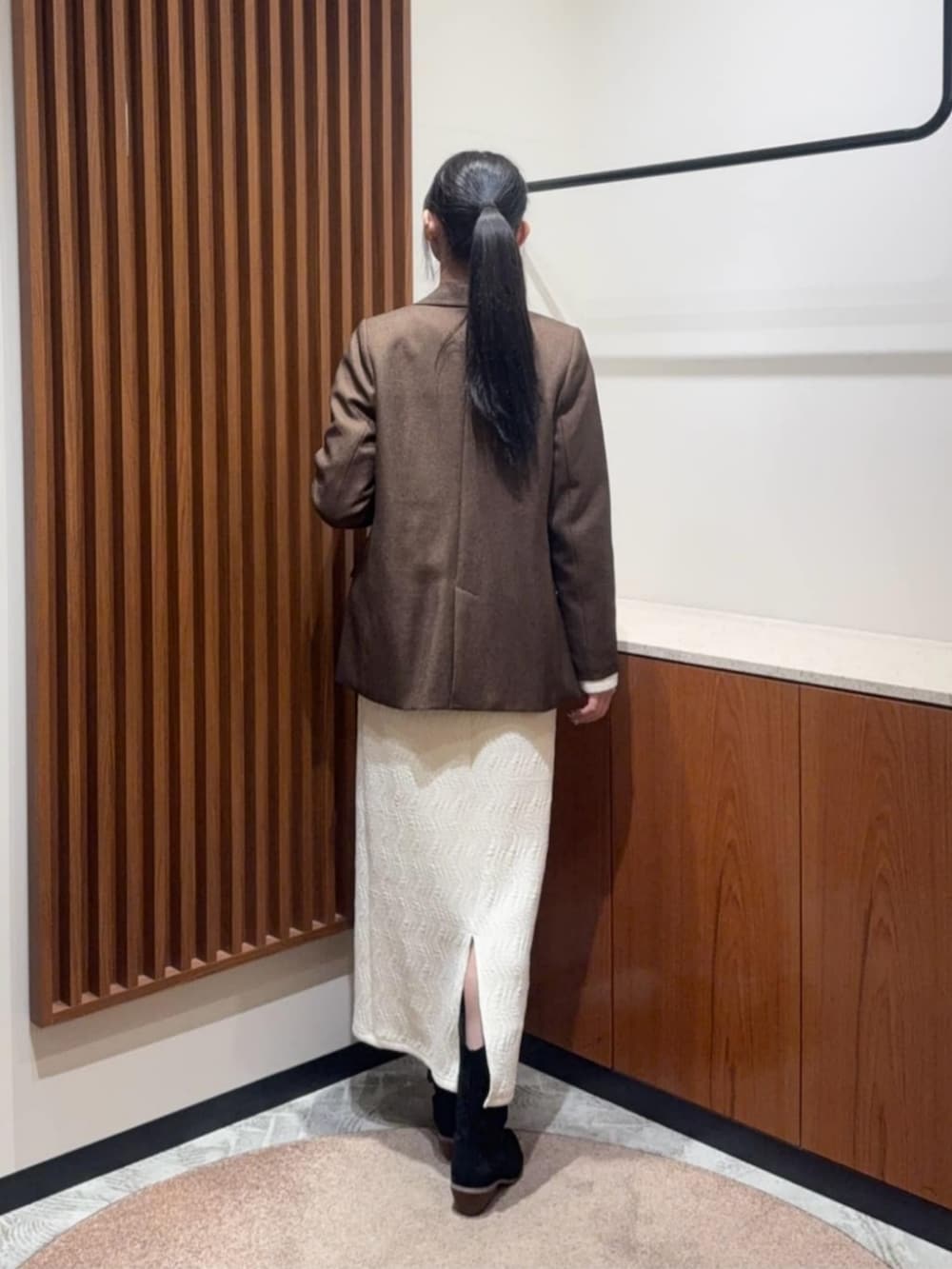 ホワイト系のセットアップ、ブラウン系のテーラードジャケットを着用したレディースの冬コーディネートの2枚目の写真