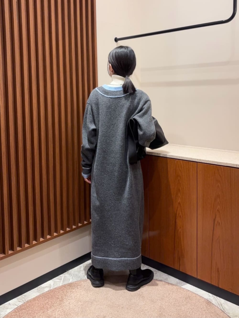 グレー系のワンピース、ホワイト系のニット/セーターを着用したレディースの冬コーディネートの3枚目の写真