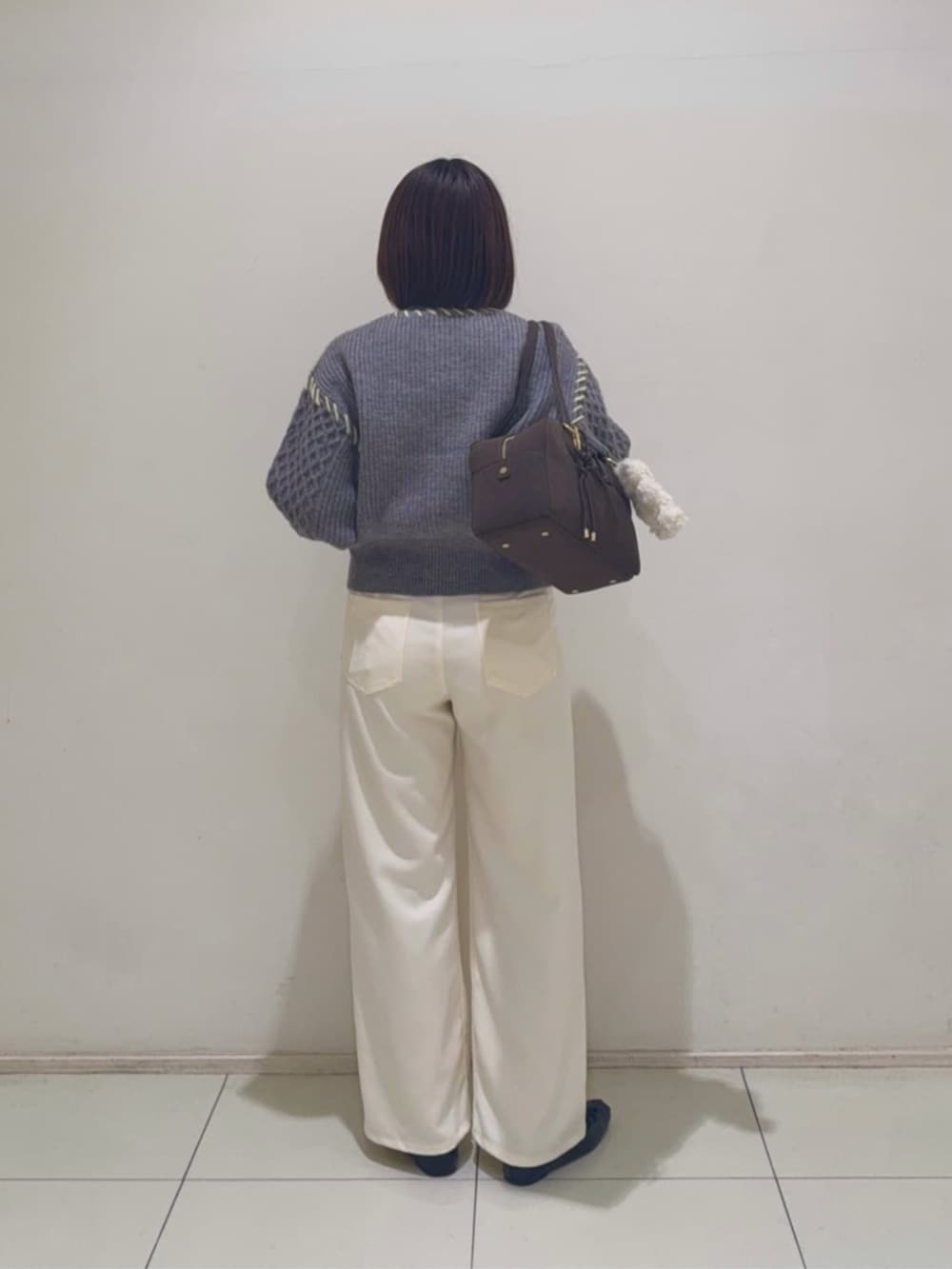 グレー系のカーディガン/ボレロ、ホワイト系のその他パンツを着用したレディースの冬コーディネートの3枚目の写真