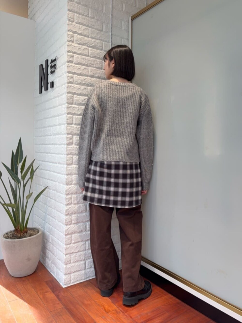 グレー系のニット/セーター、ブラック系のシャツ/ブラウスを着用したレディースの冬コーディネートの3枚目の写真