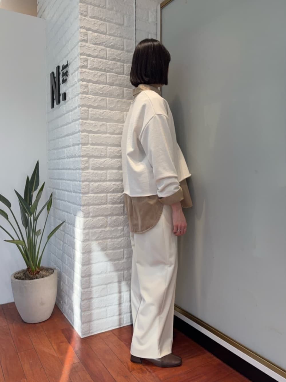 ブラウン系のピーコート、イエロー系のシャツ/ブラウス、ホワイト系のスウェットを着用したレディースの冬コーディネートの2枚目の写真