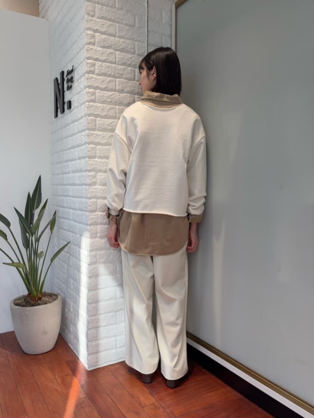 ブラウン系のピーコート、イエロー系のシャツ/ブラウス、ホワイト系のスウェットを着用したレディースの冬コーディネートの3枚目の写真