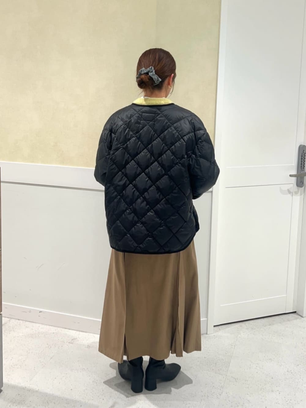 イエロー系のカーディガン/ボレロ、イエロー系のスカート、ホワイト系のシャツ/ブラウスを着用したレディースの冬コーディネートの3枚目の写真