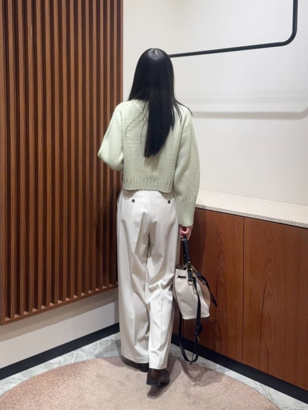 グリーン系のニット/セーター、ホワイト系のその他パンツを着用したレディースの冬コーディネートの3枚目の写真