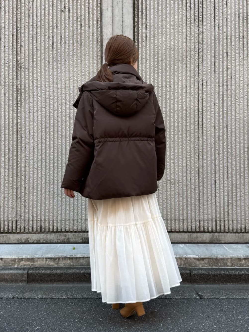 ホワイト系のスカート、ブラウン系のダウンジャケット/コートを着用したレディースの冬コーディネートの3枚目の写真