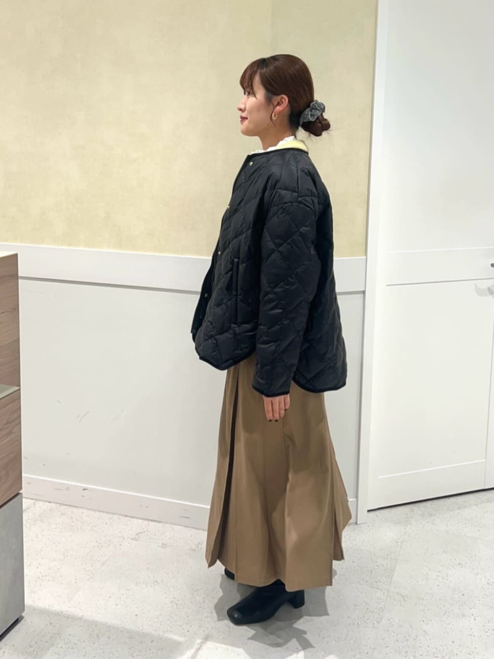 イエロー系のカーディガン/ボレロ、イエロー系のスカート、ホワイト系のシャツ/ブラウスを着用したレディースの冬コーディネートの2枚目の写真