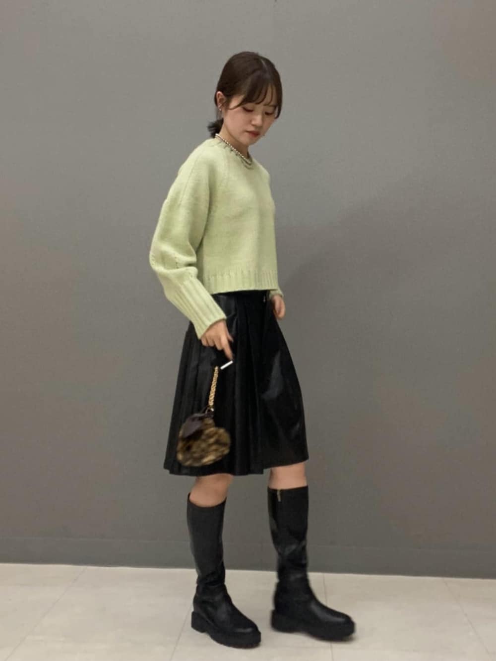 グリーン系のニット/セーター、ブラック系のその他パンツを着用したレディースの秋コーディネートの2枚目の写真