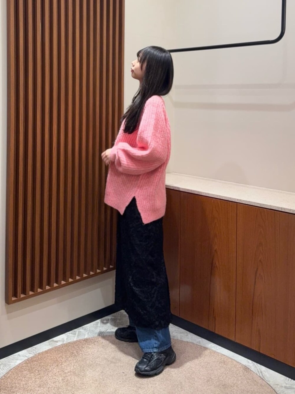 ピンク系のニット/セーター、ブラック系のスカートを着用したレディースの冬コーディネートの2枚目の写真