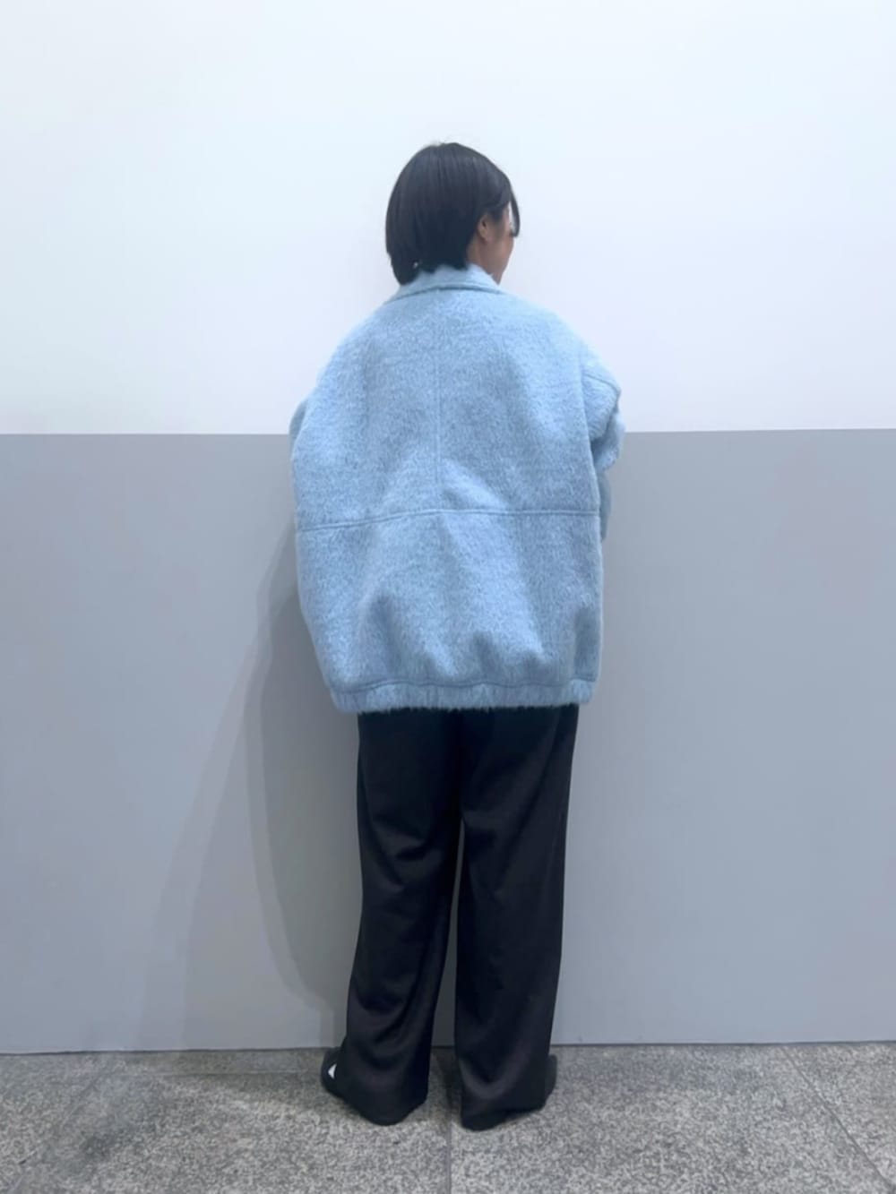 ブルー系のブルゾン、グレー系のその他パンツ、ホワイト系のニット/セーターを着用したレディースの冬コーディネートの3枚目の写真