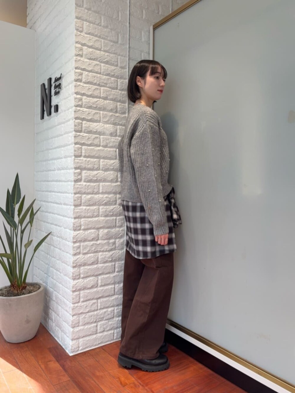 グレー系のニット/セーター、ブラック系のシャツ/ブラウスを着用したレディースの冬コーディネートの2枚目の写真