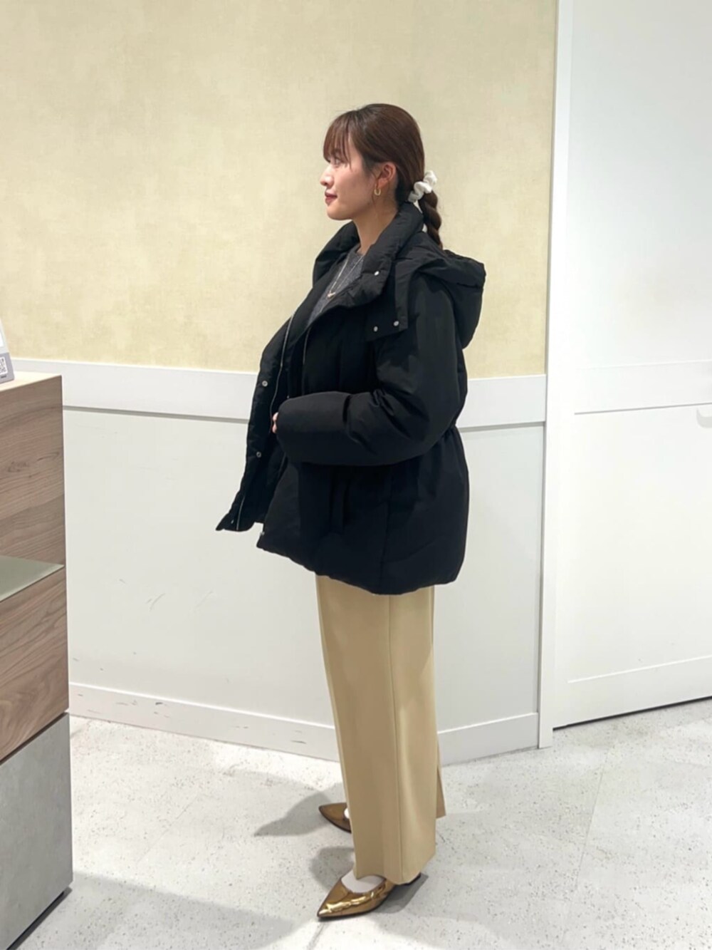 イエロー系のその他パンツ、ホワイト系のダウンジャケット/コートを着用したレディースの冬コーディネートの2枚目の写真