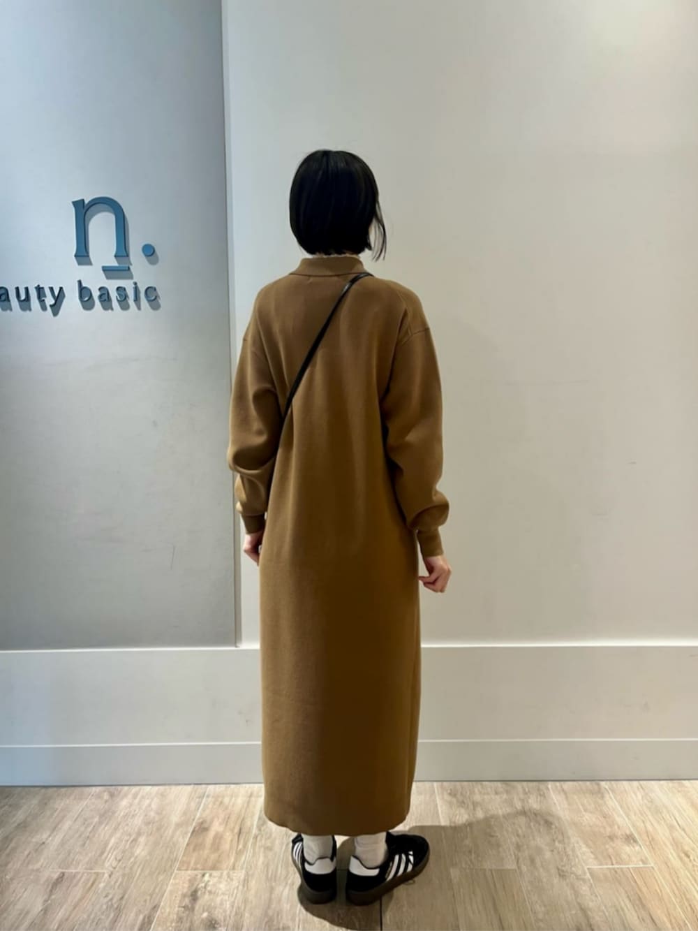 イエロー系のワンピースを着用したレディースの冬コーディネートの3枚目の写真