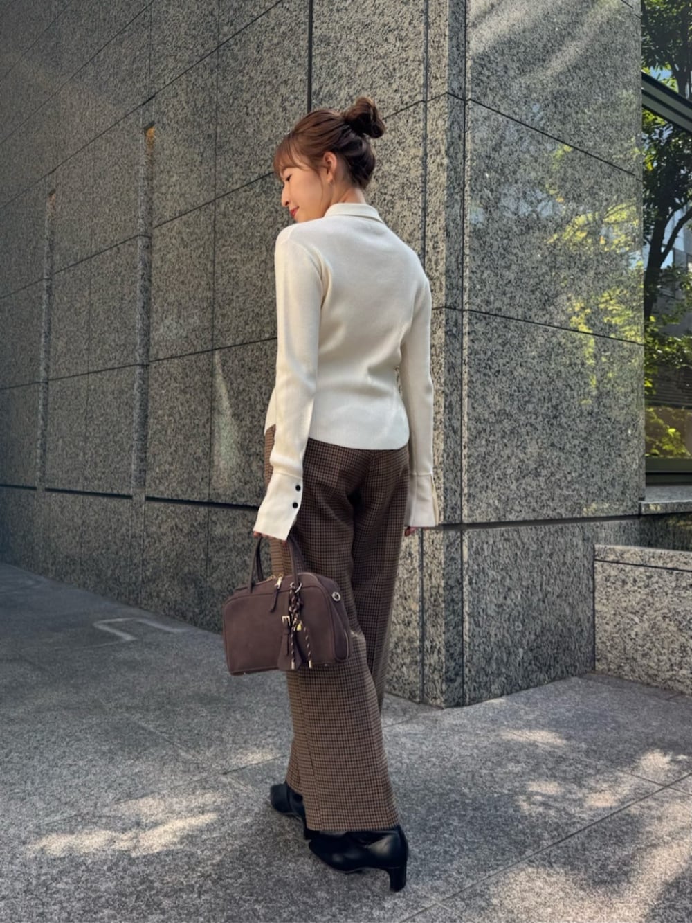 ホワイト系のニット/セーター、ブラウン系のチェスターコート、ブラウン系のその他パンツを着用したレディースの秋コーディネートの5枚目の写真