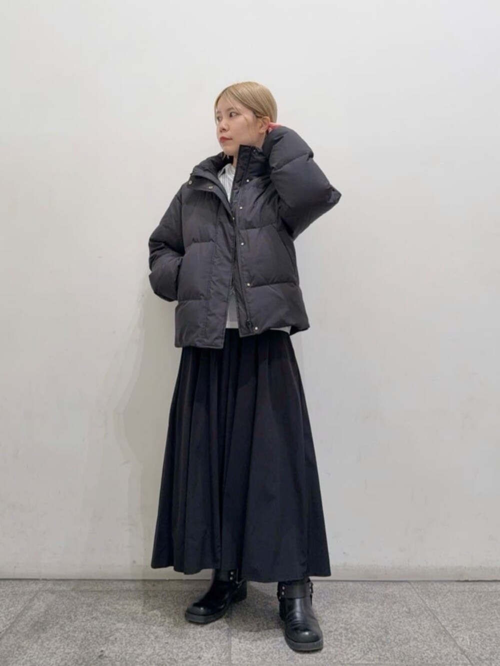 グレー系のシャツ/ブラウス、ブラック系のダウンジャケット/コート、ブラック系のスカートを着用したレディースの冬コーディネートの2枚目の写真