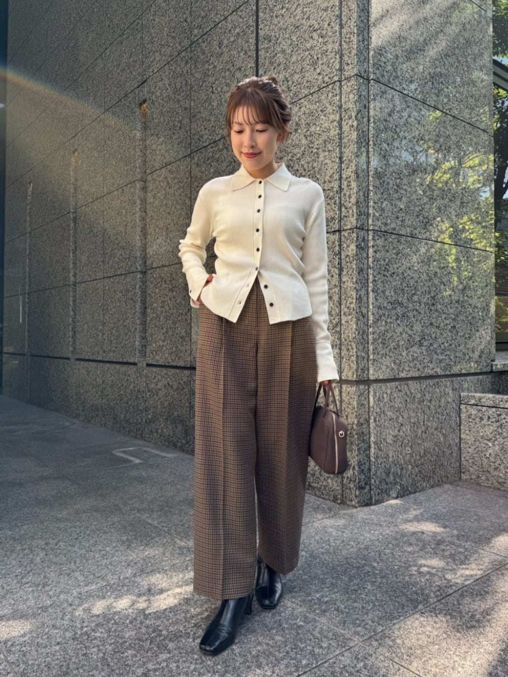 ホワイト系のニット/セーター、ブラウン系のチェスターコート、ブラウン系のその他パンツを着用したレディースの秋コーディネートの4枚目の写真