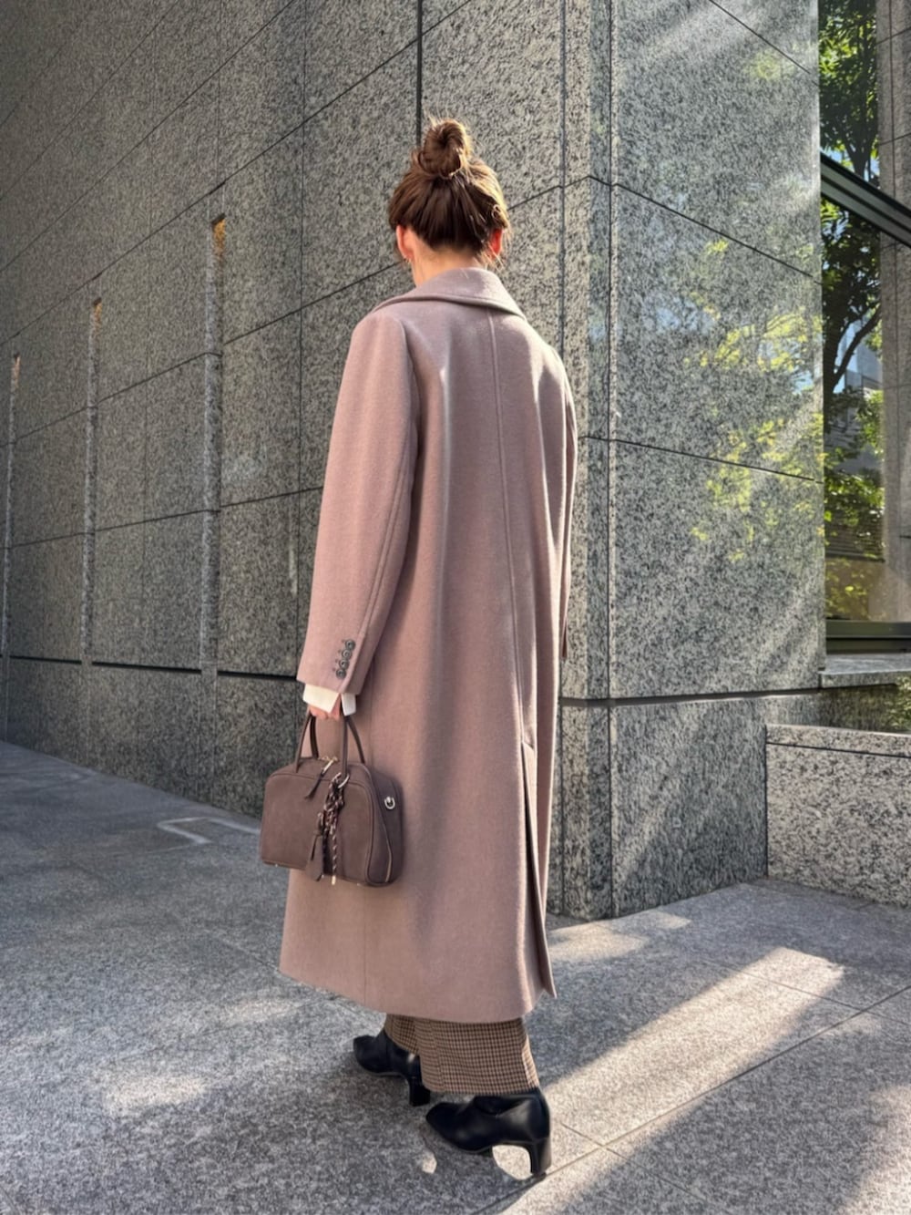 ホワイト系のニット/セーター、ブラウン系のチェスターコート、ブラウン系のその他パンツを着用したレディースの秋コーディネートの3枚目の写真