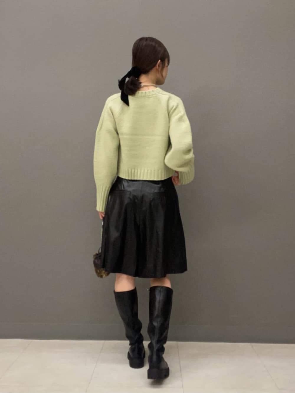 グリーン系のニット/セーター、ブラック系のその他パンツを着用したレディースの秋コーディネートの3枚目の写真