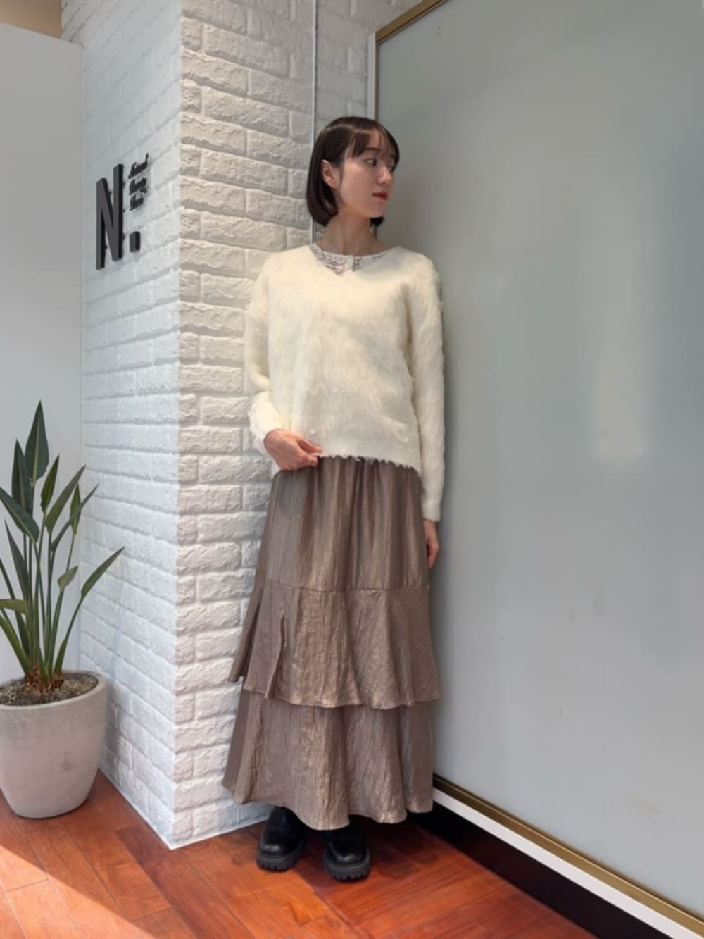 ベージュ系のノーカラーコートを着用したレディースの冬コーディネートの4枚目の写真