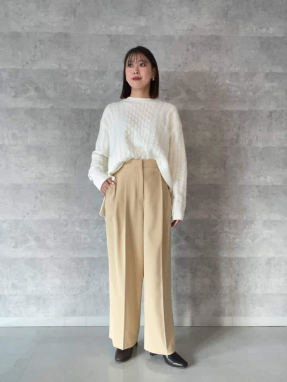 ベージュ系のノーカラーコート、イエロー系のその他パンツ、ホワイト系のニット/セーターを着用したレディースの冬コーディネートの4枚目の写真