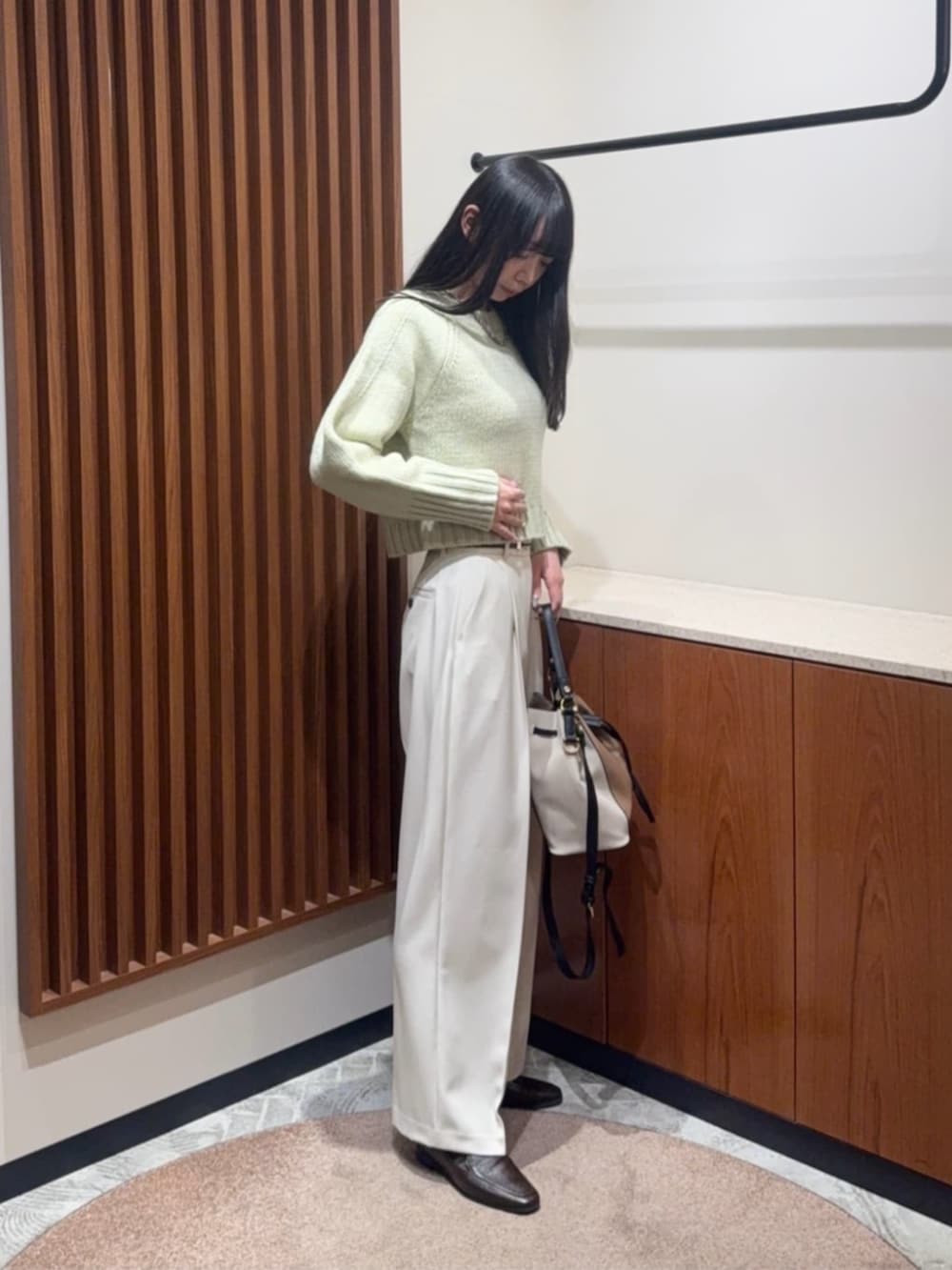 グリーン系のニット/セーター、ホワイト系のその他パンツを着用したレディースの冬コーディネートの2枚目の写真