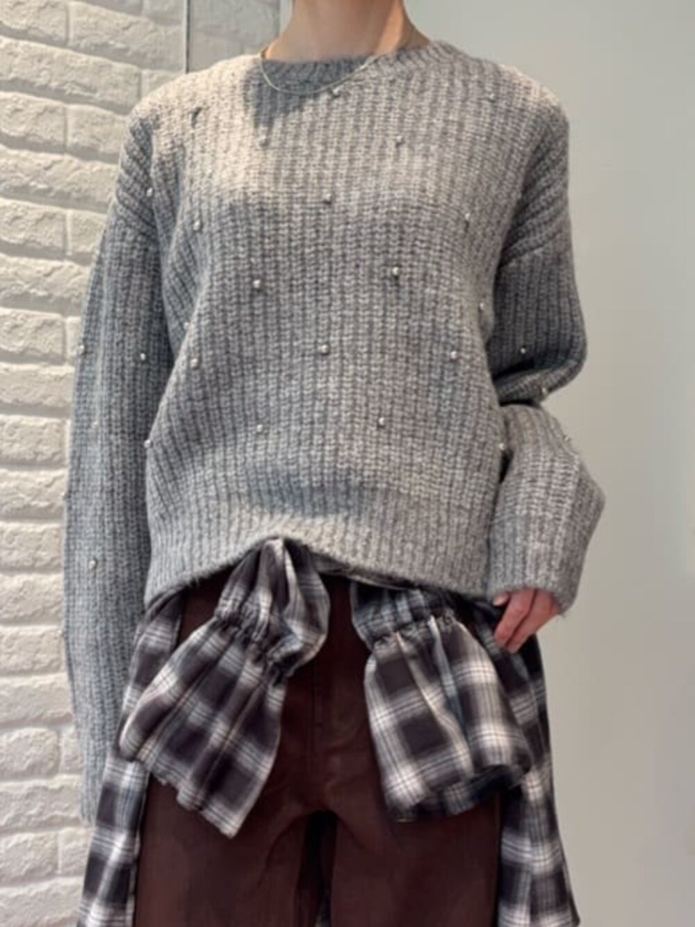 グレー系のニット/セーター、ブラック系のシャツ/ブラウスを着用したレディースの冬コーディネートの4枚目の写真