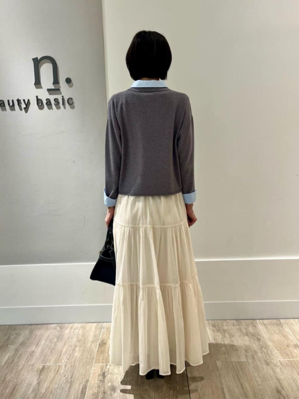 ホワイト系のスカート、グレー系のニット/セーターを着用したレディースの冬コーディネートの3枚目の写真