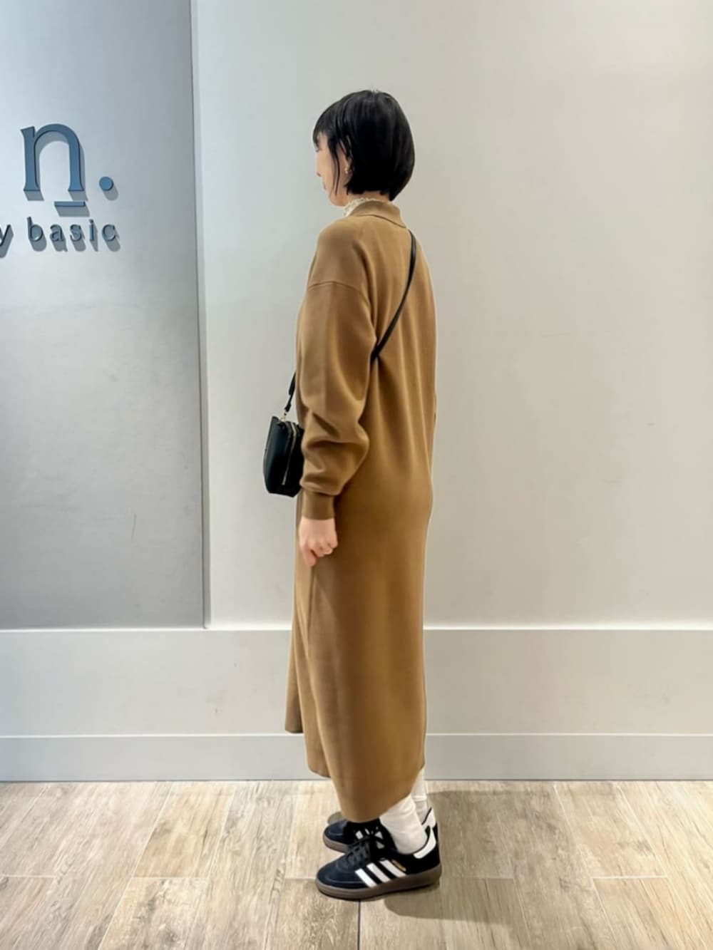 イエロー系のワンピースを着用したレディースの冬コーディネートの2枚目の写真