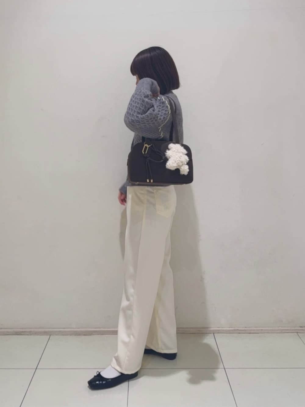 グレー系のカーディガン/ボレロ、ホワイト系のその他パンツを着用したレディースの冬コーディネートの2枚目の写真