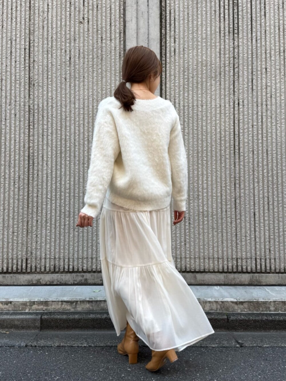 ホワイト系のスカート、ブラウン系のダウンジャケット/コートを着用したレディースの冬コーディネートの5枚目の写真