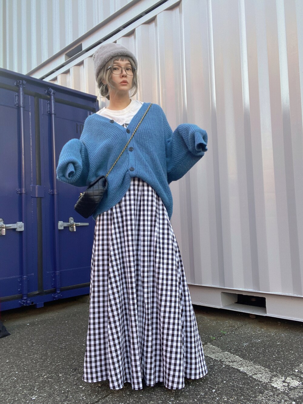 ブルー系のデニムジャケット、ブルー系のカーディガン/ボレロ、ブラック系のスカートを着用したレディースの秋コーディネートの3枚目の写真