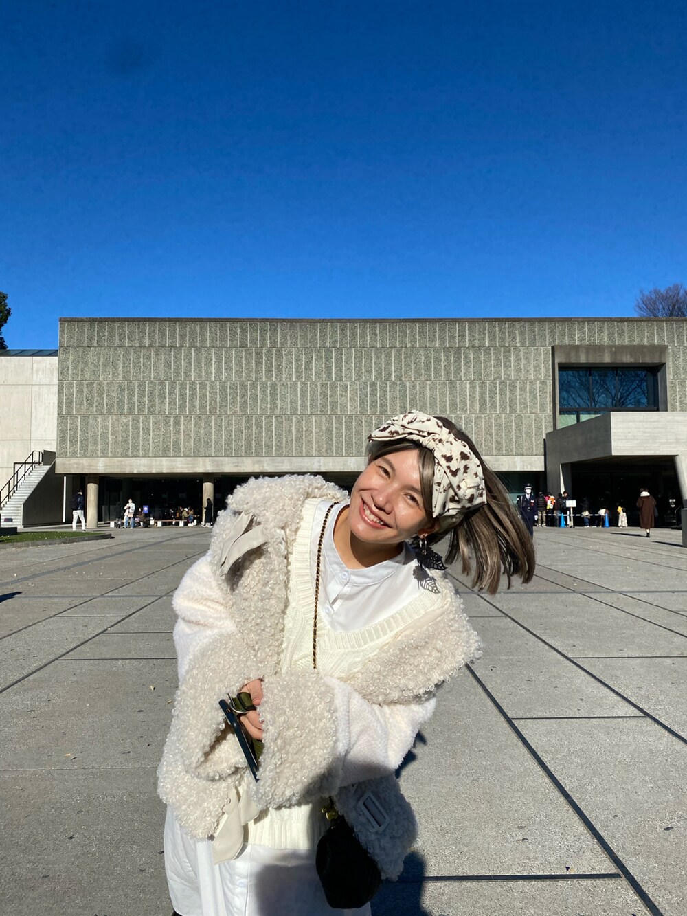 ホワイト系のその他アウター、ブラック系のシューズを着用したレディースの冬コーディネートの2枚目の写真