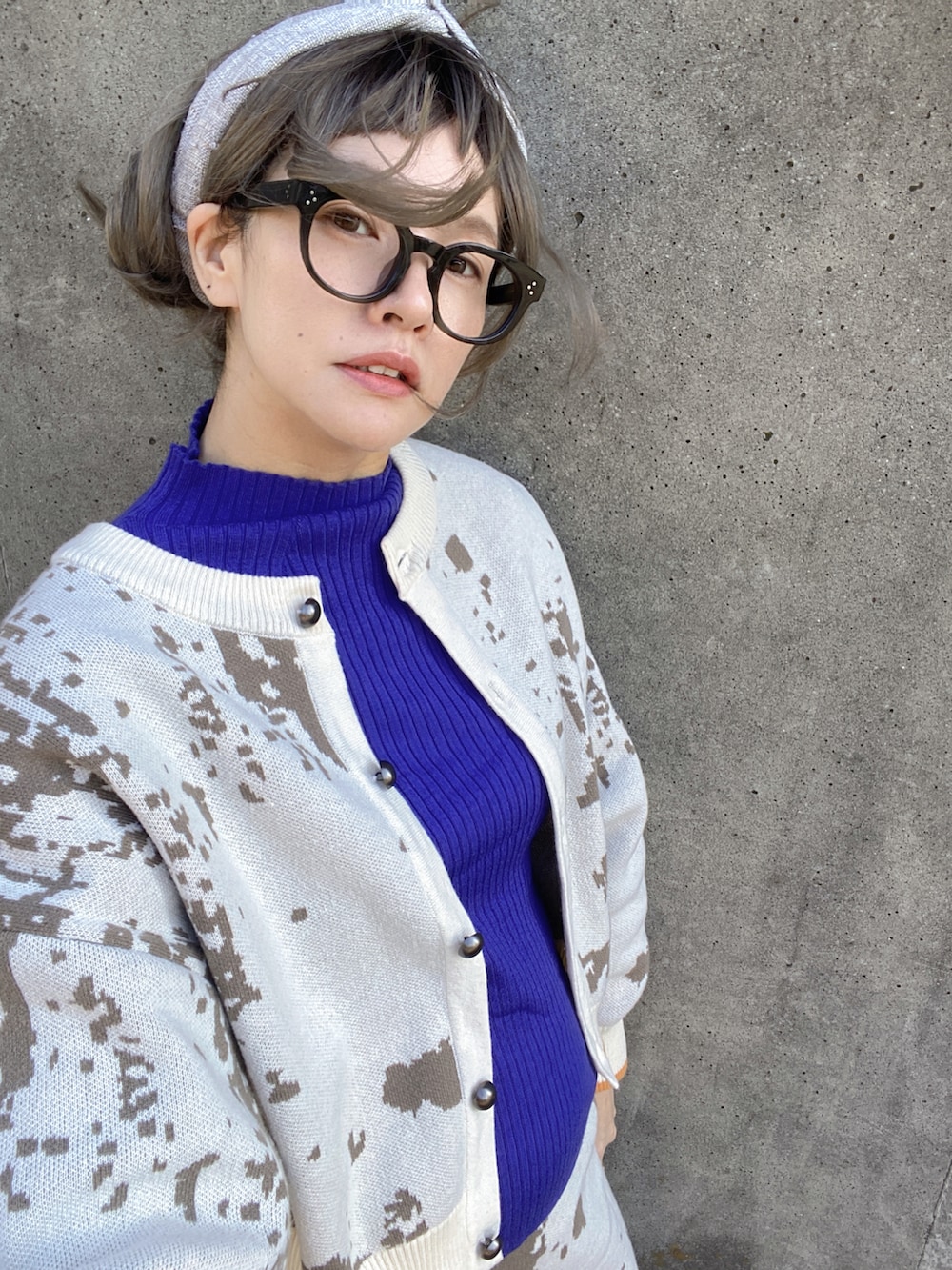 ホワイト系のカーディガン/ボレロ、ホワイト系のスカート、ブルー系のスニーカーを着用したレディースの春コーディネートの3枚目の写真