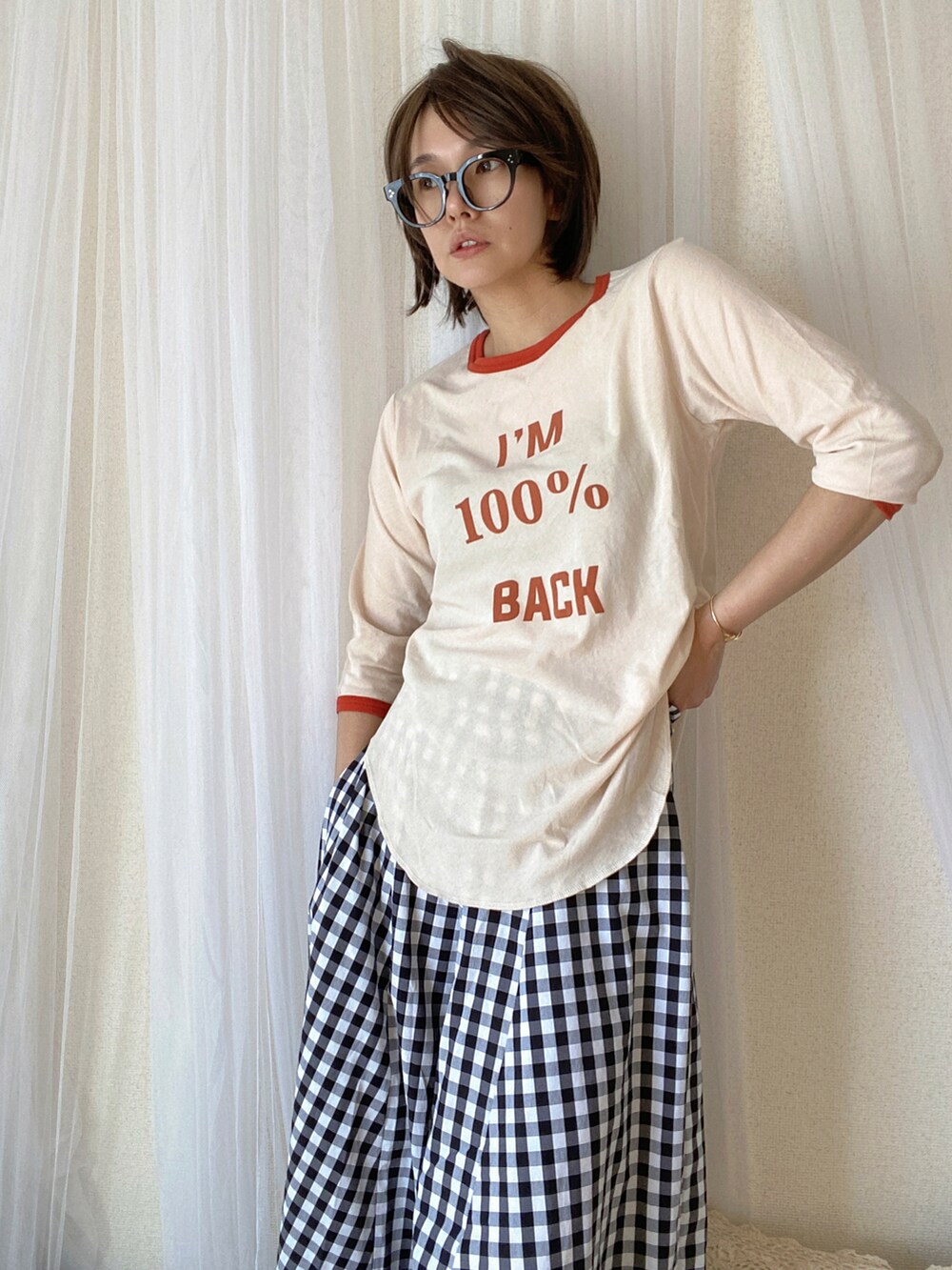 オレンジ系のTシャツ/カットソー、ブラック系のスカート、ブラック系のライダースジャケットを着用したレディースの冬コーディネートの3枚目の写真