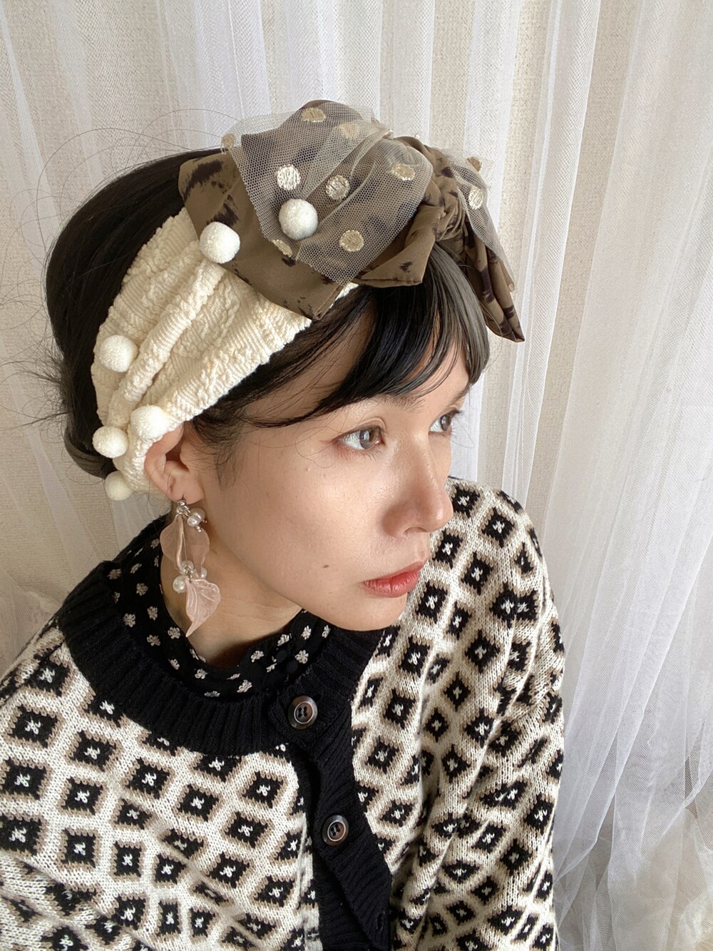 ブラック系のワンピース、ホワイト系のカーディガン/ボレロ、シルバー系のシューズを着用したレディースの春コーディネートの3枚目の写真