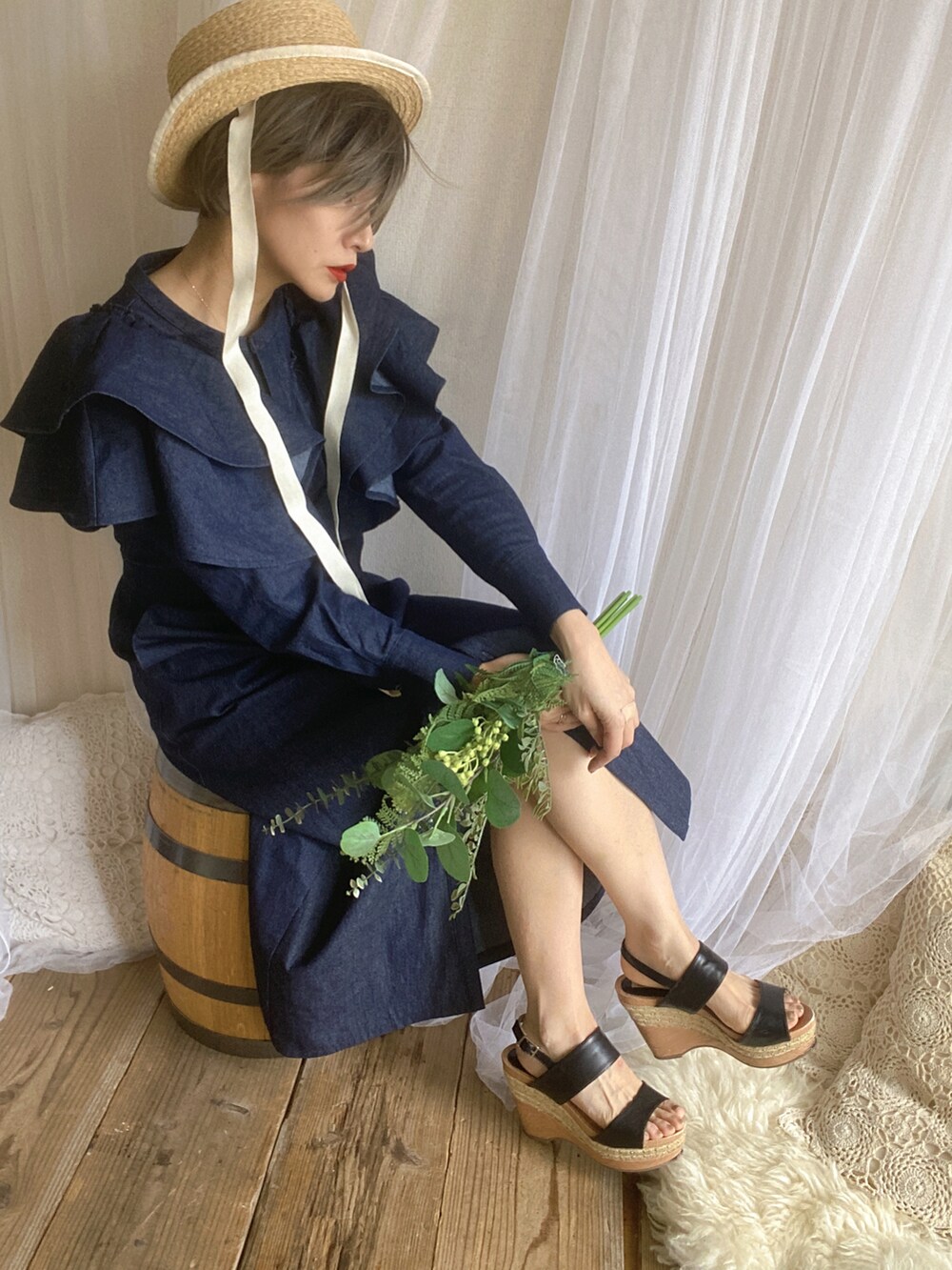 ブルー系のワンピース、ブラック系のサンダル、ホワイト系のハットを着用したレディースの春コーディネートの2枚目の写真