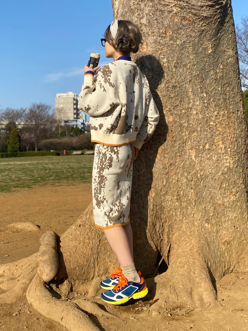 ホワイト系のカーディガン/ボレロ、ホワイト系のスカート、ブルー系のスニーカーを着用したレディースの春コーディネートの2枚目の写真