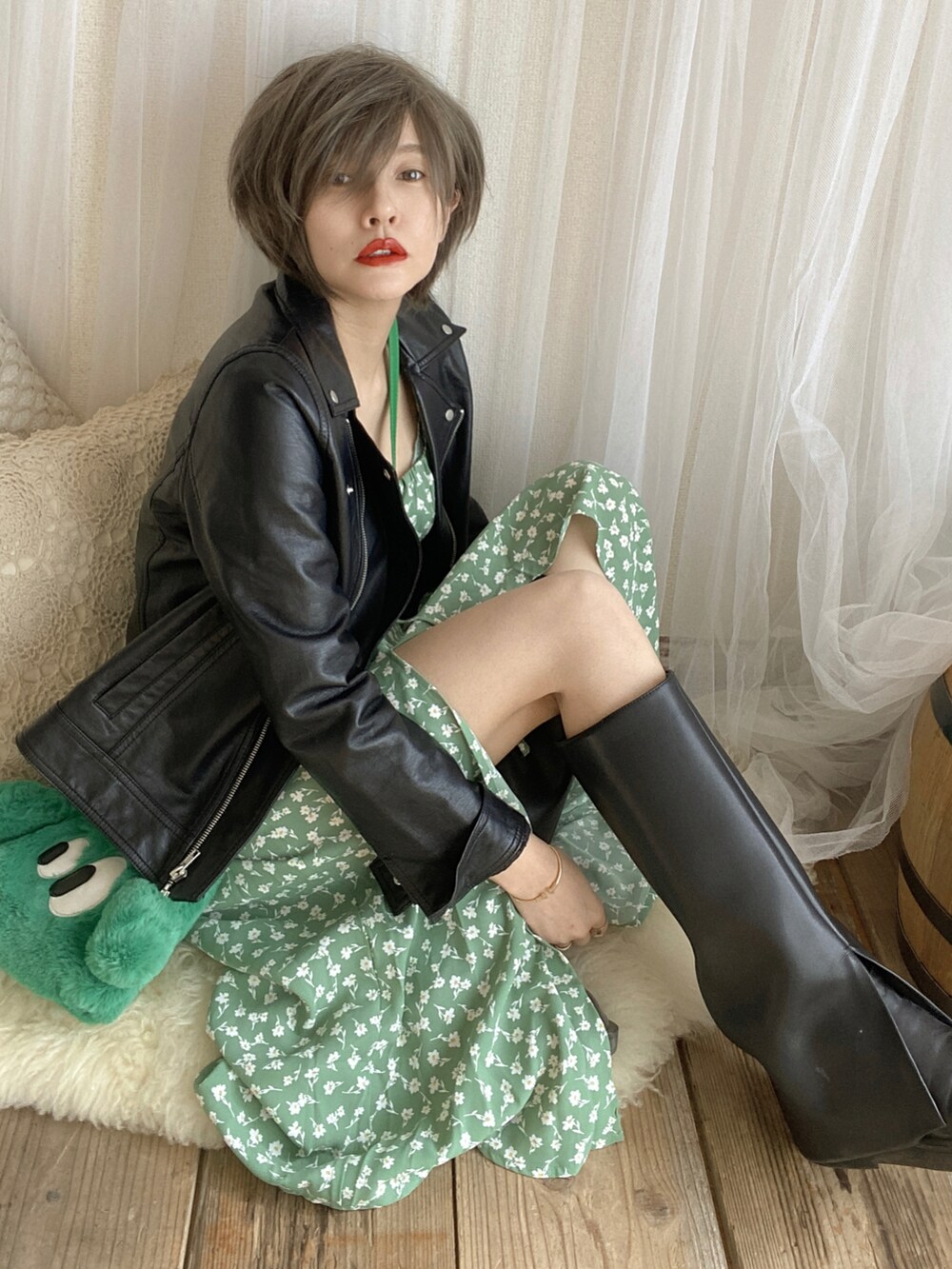 グリーン系のワンピース、グリーン系のバッグ、ブラック系のジャケット/アウターを着用したレディースの冬コーディネートの2枚目の写真