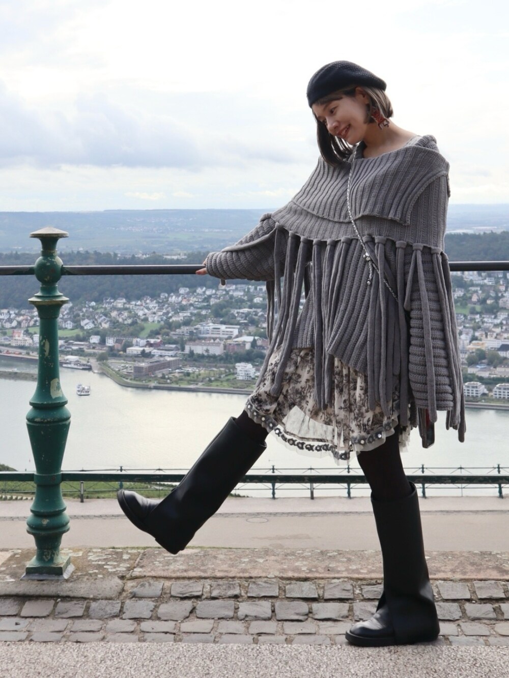 グレー系のニット/セーター、ブラック系のシューズ、ホワイト系のワンピース/ドレスを着用したレディースの冬コーディネートの2枚目の写真