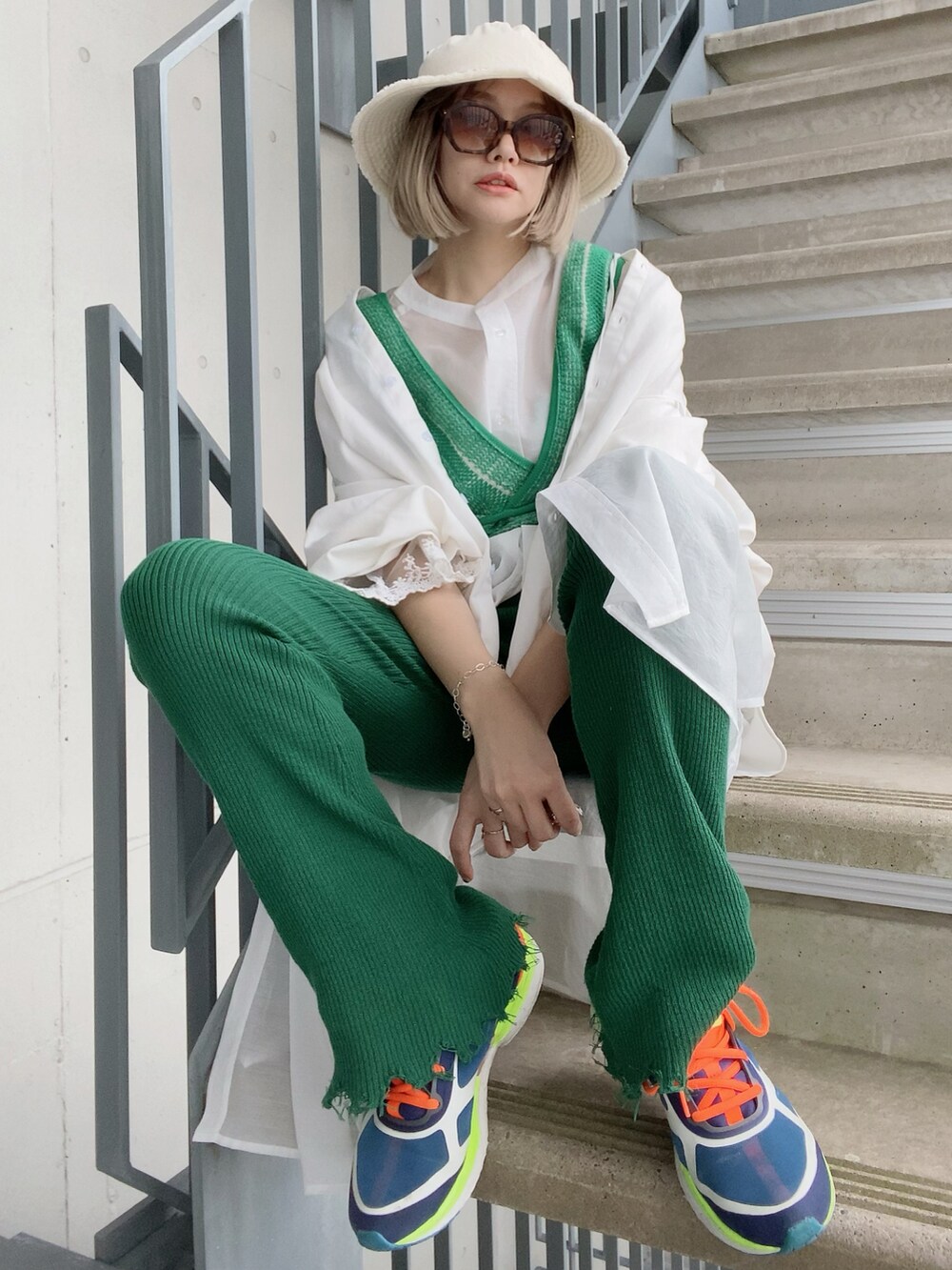 グリーン系のベスト、グリーン系のその他パンツ、ブルー系のスニーカーを着用したレディースの春コーディネートの2枚目の写真