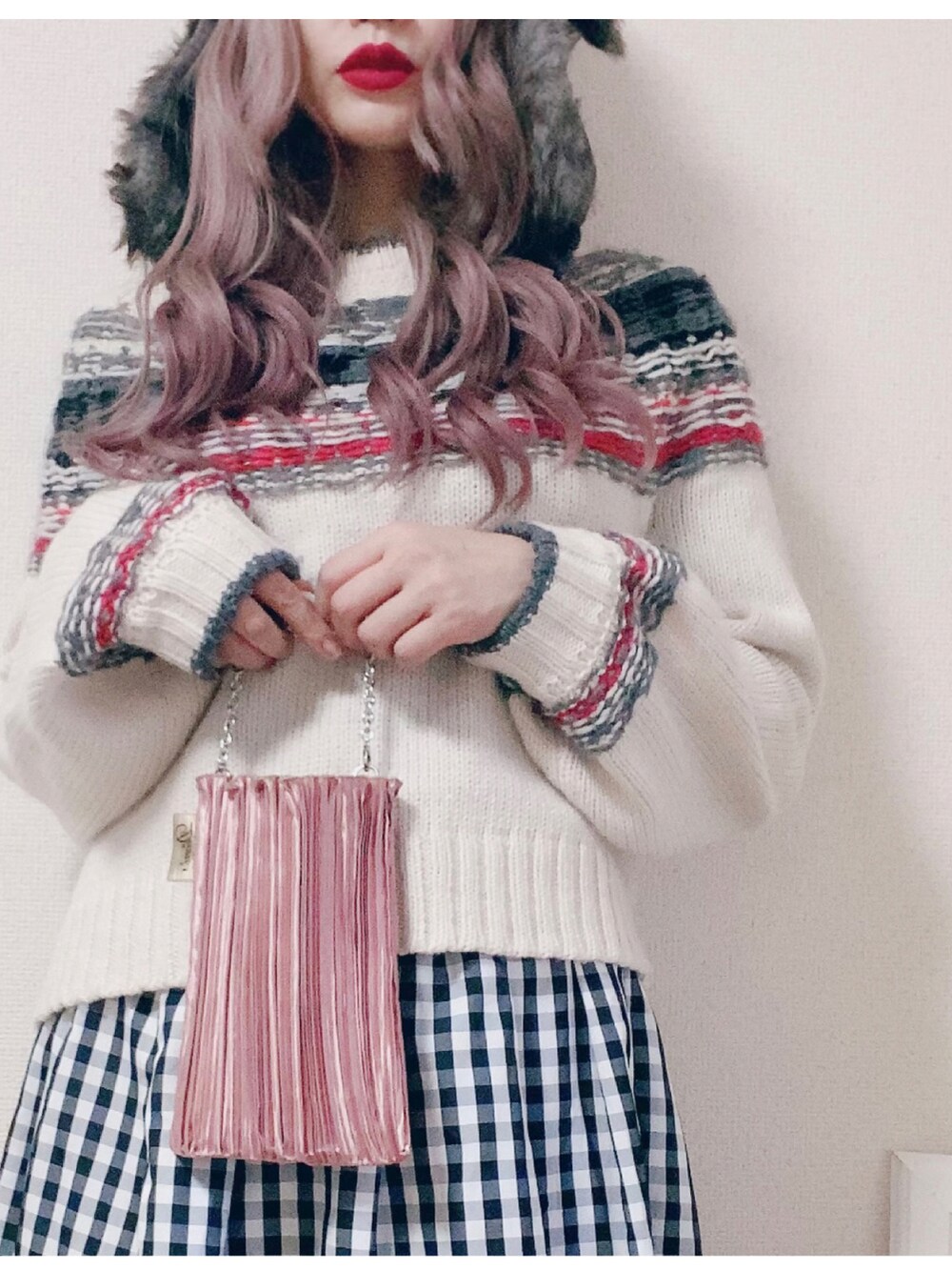 ブラック系のスカート、ホワイト系のニット/セーター、ピンク系のバッグを着用したレディースの秋コーディネートの2枚目の写真