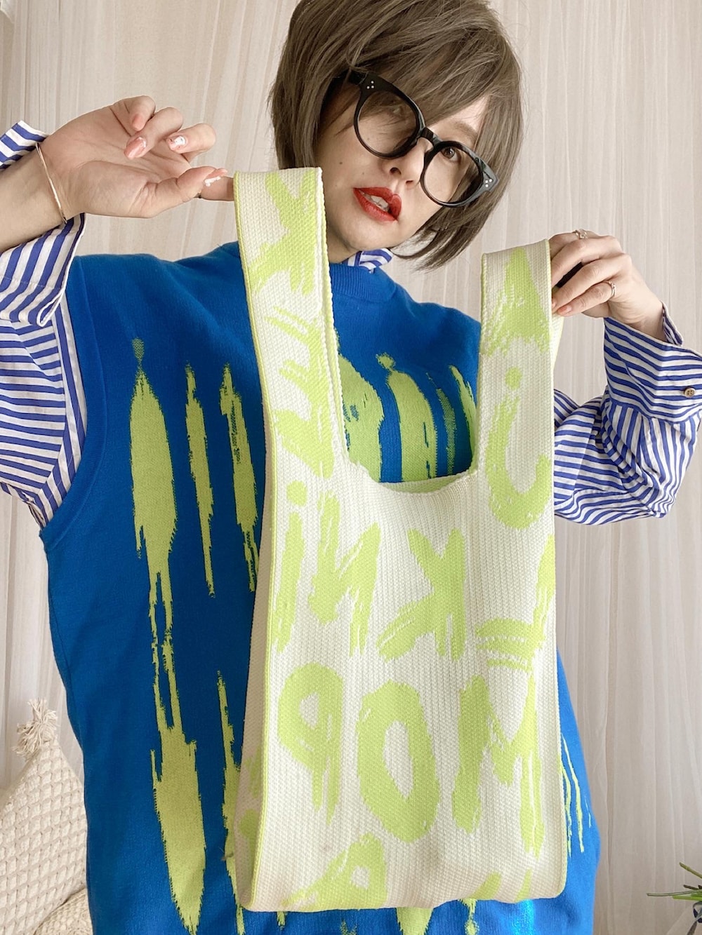 グリーン系のスニーカー、ブルー系のシャツワンピース、ブルー系のベストを着用したレディースの冬コーディネートの5枚目の写真