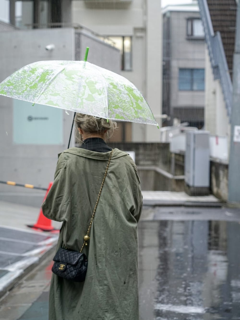 グリーン系のジャケット/アウター、ホワイト系のスカート、ブラック系のシューズを着用したレディースの春コーディネートの2枚目の写真