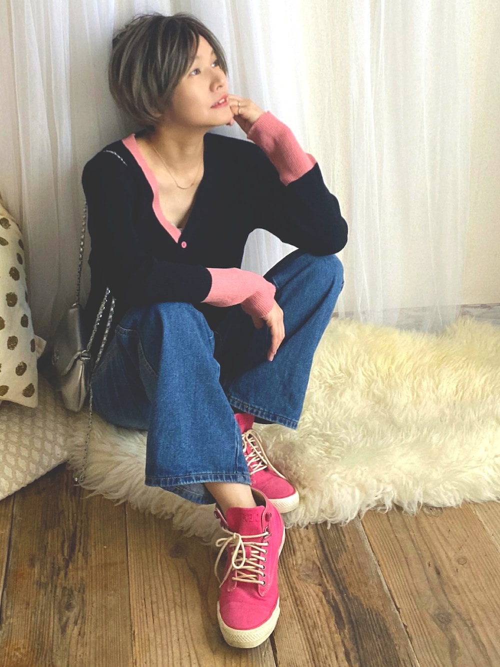 ブラック系のカーディガン/ボレロ、ブルー系のデニムパンツ、ピンク系のスニーカーを着用したレディースの冬コーディネートの2枚目の写真