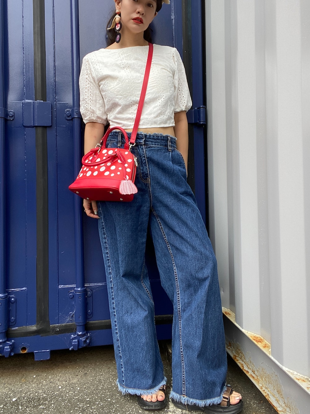 ホワイト系のシャツ/ブラウス、レッド系のバッグ、ブルー系のデニムパンツを着用したレディースの夏コーディネートの3枚目の写真