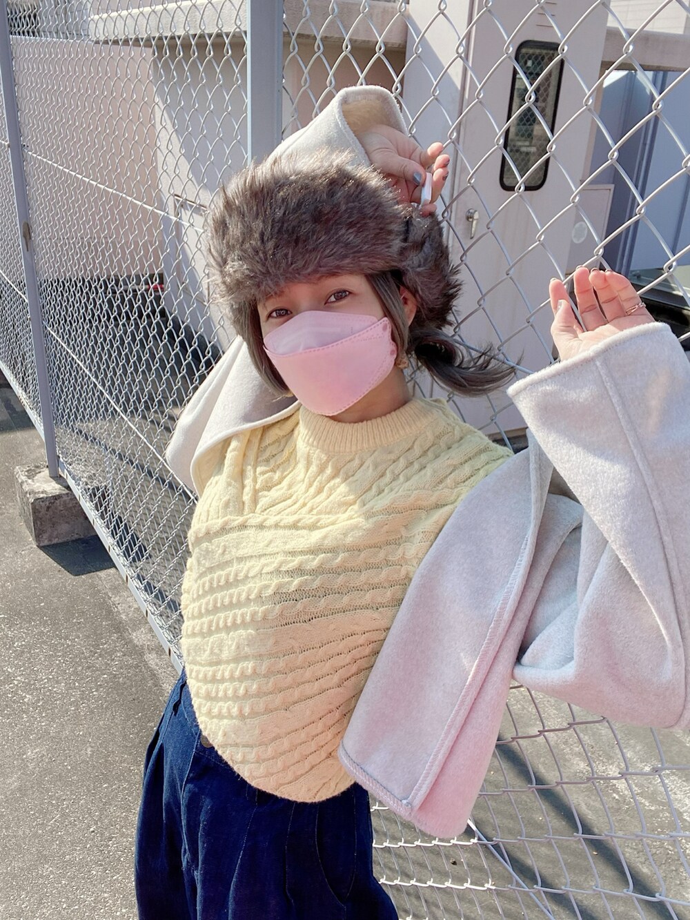 ブルー系のデニムパンツ、イエロー系のシューズ、グレー系のキャップを着用したレディースの冬コーディネートの5枚目の写真