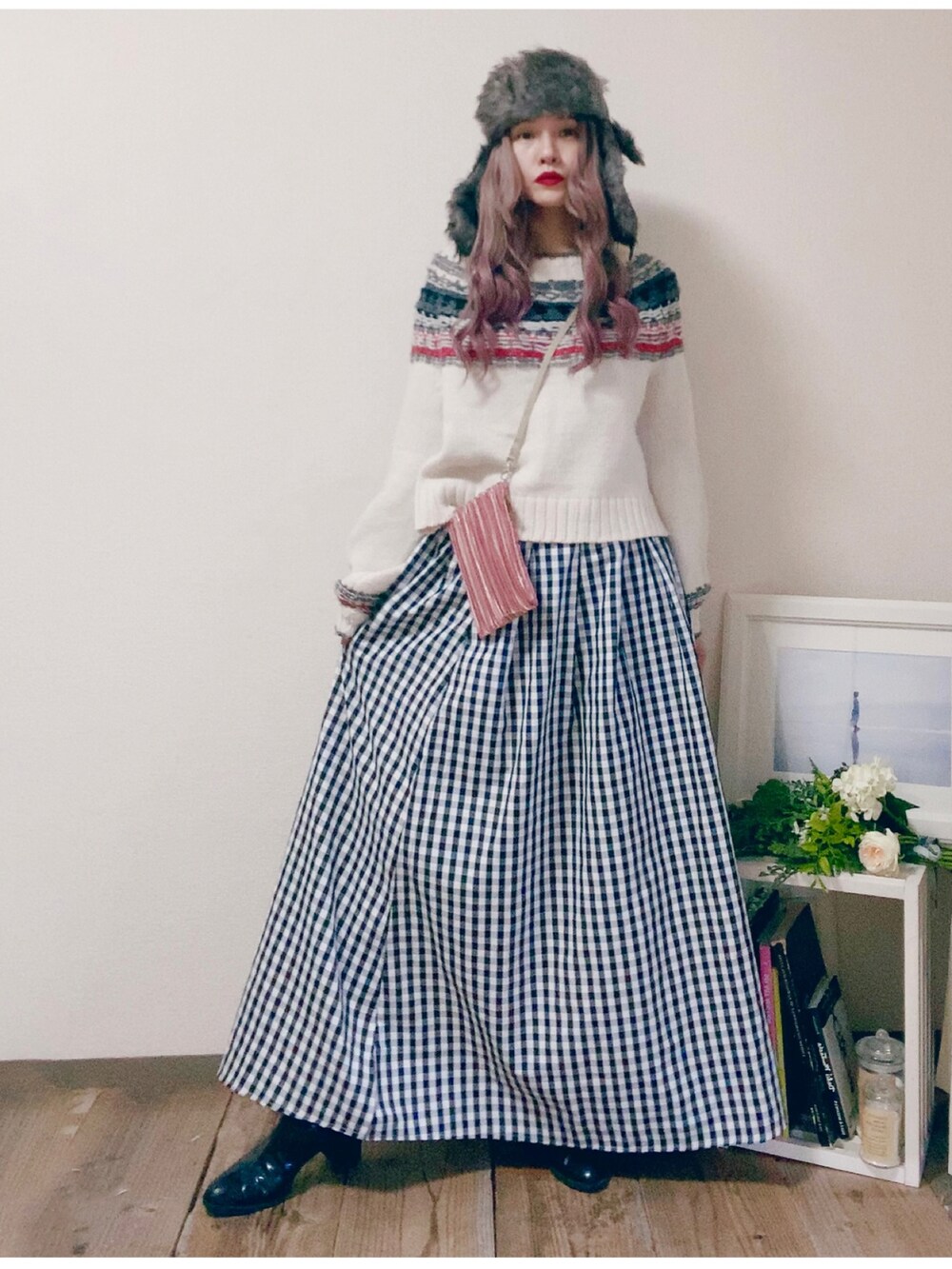 ブラック系のスカート、ホワイト系のニット/セーター、ピンク系のバッグを着用したレディースの秋コーディネートの3枚目の写真